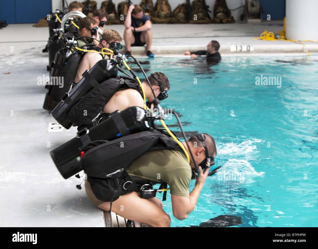Marines dive into the pool during a battalion training event at Camp Lejeune, N.C., March 23, 2017. The self-contained underwater breathing apparatus provides Marines with deep-water diving capabilities essential for conducting real-world scenarios. The Marines are with 2nd Reconnaissance Battalion, 2nd Marine Division. Stock Photo