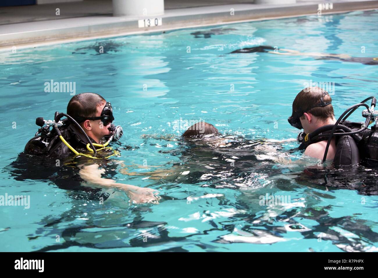 Marines conduct dive training in small groups to ensure safety in the pool during a battalion training event at Camp Lejeune, N.C., March 23, 2017. The Marines conducted training with the self-contained underwater breathing apparatus to maintain proficiency and confidence in their combat diving skills. The Marines are with 2nd Reconnaissance Battalion, 2nd Marine Division. Stock Photo