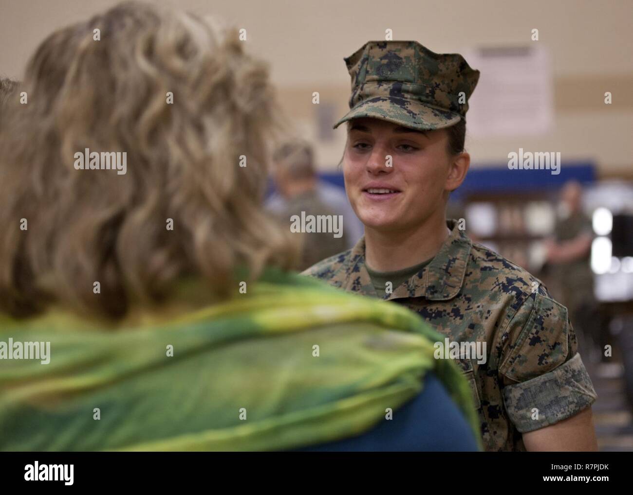U.S. Marine Corps Pfc. Maria Daume, a mortarman assigned to Bravo Company, Infantry Training Battalion, School of Infantry-East, is congratulated after graduating from the Basic Mortarman course aboard Camp Geiger, N.C., March 23, 2017. The purpose of the Mortarman is to provide fire in support of maneuver elements using light, medium, and heavy mortars. Stock Photo