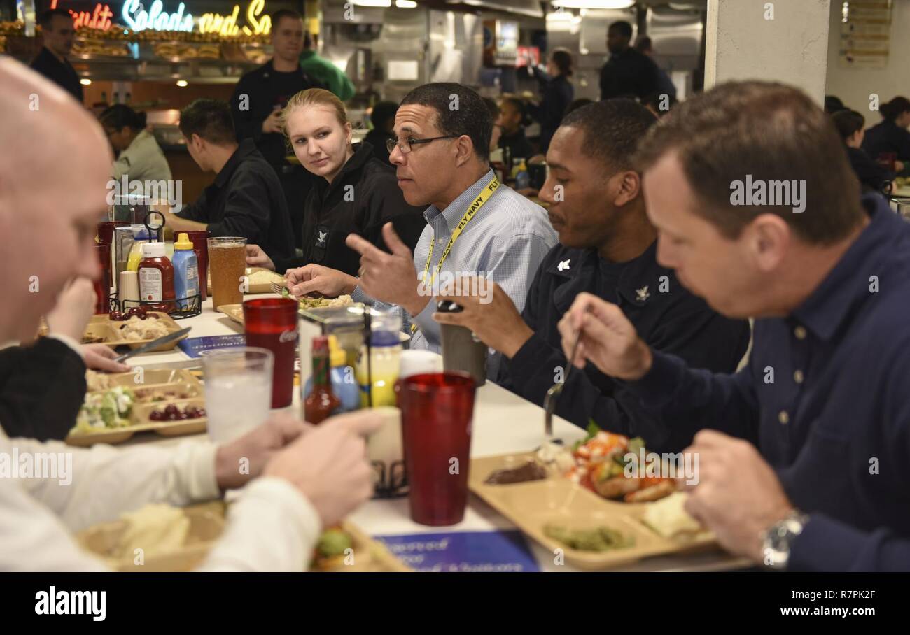 PACIFIC OCEAN (March 26, 2017) Congressman Anthony Brown (D-MD), eats with Sailors from Maryland on the mess decks during a visit to the aircraft carrier USS Nimitz (CVN 68). Nimitz is currently underway conducting Composite Training Unit Exercise (COMPTUEX) with the Nimitz Carrier Strike in preparation for an upcoming deployment. COMPTUEX tests a carrier strike group's mission-readiness and ability to perform as an integrated unit through simulated real-world scenarios. Stock Photo