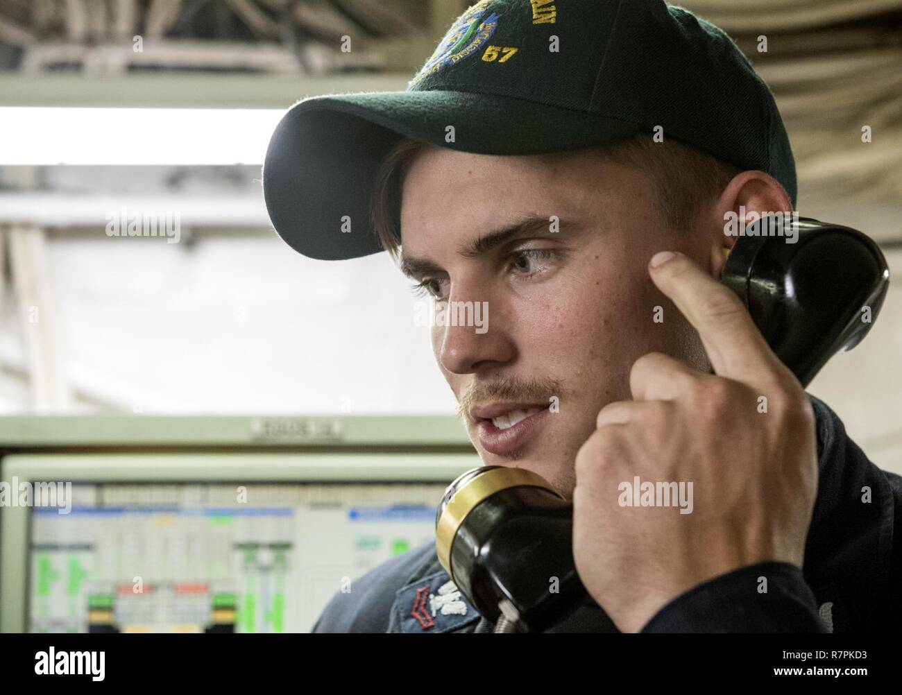 U.S. 7TH FLEET AREA OF OPERATIONS (March 20, 2017) Machinist’s Mate 2nd Class Dakota Anders, from Hartselle, Alabama, passes a message using an X5J telephone during an engineering training drill aboard Ticonderoga-class guided-missile cruiser USS Lake Champlain (CG 57). Lake Champlain is on a regularly scheduled Western Pacific deployment with the Carl Vinson Carrier Strike Group as part of the U.S. Pacific Fleet-led initiative to extend the command and control functions of the U.S. 3rd Fleet in the Indo-Asia-Pacific region. Navy aircraft carrier strike groups have patrolled the Indo-Asia-Paci Stock Photo