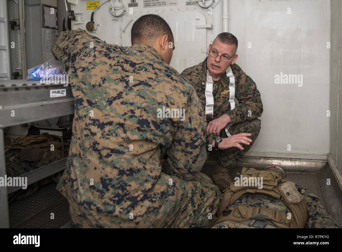 PHILIPPINE SEA (March 27, 2017) Cmdr. William Riley, the command chaplain assigned to the 31st Marine Expeditionary Unit (MEU), from Myerstown, Pa., trains Religious Programs Specialist Seaman Anthony Woodcasella, from Norwell, Mass., on the proper procedure to administer rites during a certification exercise (CERTEX) mass casualty drill aboard the amphibious assault ship USS Bonhomme Richard (LHD 6). A mass casualty drill is an exercise conducted to ensure medical responders can quickly and efficiently provide treatment to injured personnel. Bonhomme Richard, flagship of the Bonhomme Richard  Stock Photo