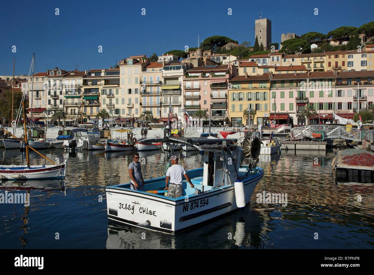 France, Alpes Maritimes, Cannes, Fishermen in their traditional fishboat in the Old port, with the district of the Suquet in the background Stock Photo