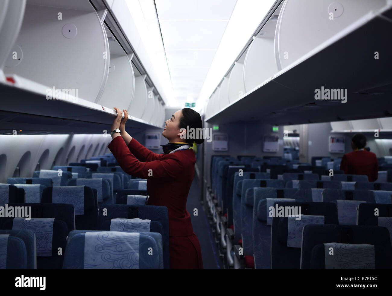 (181211) -- BEIJING, Dec. 11, 2018 (Xinhua) -- A stewardess checks the compartment on flight CA935 after arrival at Frankfurt Airport in Frankfurt, Germany, Dec. 1, 2018. The Civil Aviation Administration of China published an action plan on Monday, aiming to make China's civil aviation industry one of the best in the world by 2050. Under the plan, from 2021 to 2035, China will comprehensively enhance the strength of its civil aviation industry to not only take the lead in air transportation, but also have the world's most competitive airlines and aviation hubs, advanced air service Stock Photo