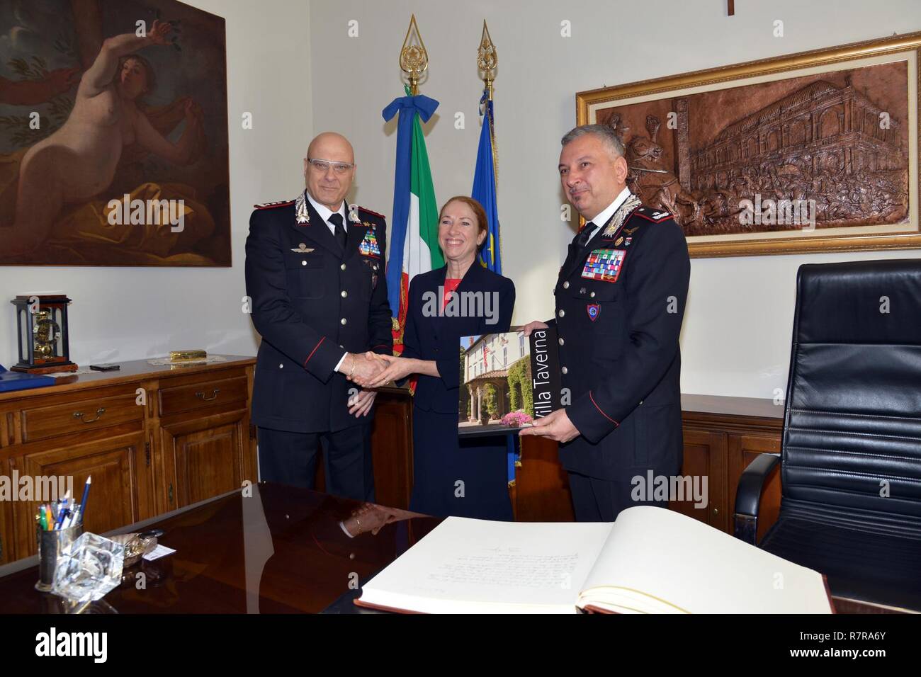 Lt. Gen Vincenzo Coppola (left), Commanding General “Palidoro” Carabinieri Specialized, Brig. Gen. Giovanni Pietro Barbano Center of Excellence for Stability Police Units (CoESPU) director (right), receives a gift from Ms. Kelly Degnan, Charge’ d’Affaires ad interim U.S. Embassy & Consulates Italy, during visit at Center of Excellence for Stability Police Units (CoESPU) Vicenza, Italy, Mar. 30, 2017. Stock Photo