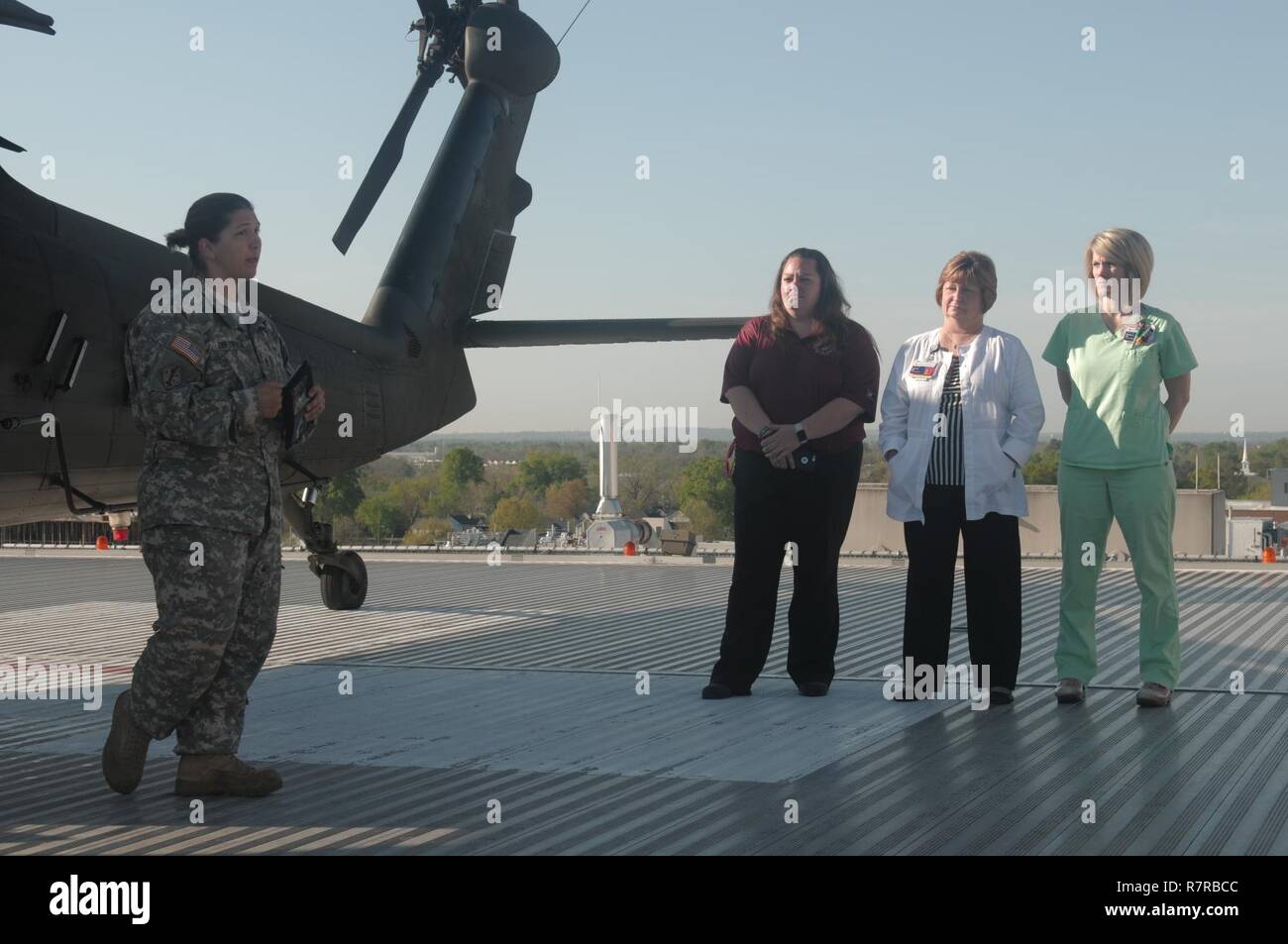 AUGUSTA UNIVERSITY MEDICAL HOSPITAL, Augusta, Ga., March 29, 2017 - Georgia Army National Guardsman Staff Sgt. Anna Dietrich, from Detachment 2, Charlie Company, 1st Battalion, 169th Aviation Regiment, speaks with civilian personnel atop Augusta University Medical Hospital during the Vigilant Guard 17 training exercise. Stock Photo