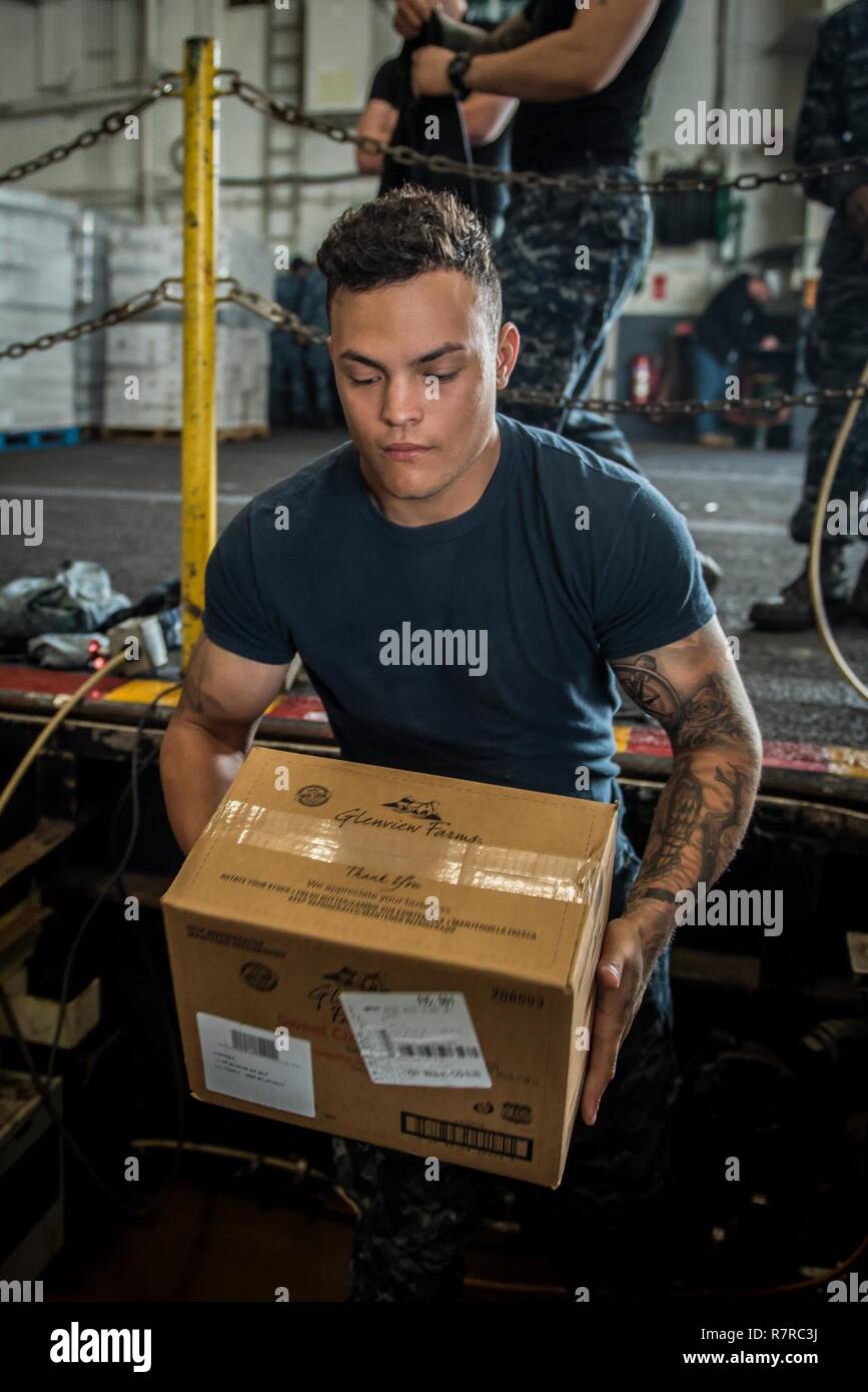 SAN DIEGO (Mar. 30, 2017) Airman Dante Hernandez loads boxes of food onto a food stores elevator in the hangar bay of the aircraft carrier USS Theodore Roosevelt (CVN 71). Theodore Roosevelt is currently moored and homeported at Naval Air Station North Island. Stock Photo