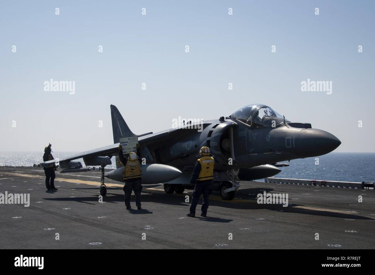 EAST CHINA SEA (April 3, 2017) Aviation Boatswain's Mates (Handling) use a jet board to communicate with an AV-8B Harrier pilot, assigned to the 'Tomcats' of Marine Attack Squadron (VMA) 311, prior to takeoff from the flight deck of the amphibious assault ship USS Bonhomme Richard (LHD 6). Bonhomme Richard, flagship of the Bonhomme Richard Expeditionary Strike Group, with embarked 31st Marine Expeditionary Unit, is on a routine patrol, operating in the Indo-Asia-Pacific region to enhance warfighting readiness and posture forward as a ready-response force for any type of contingency. Stock Photo