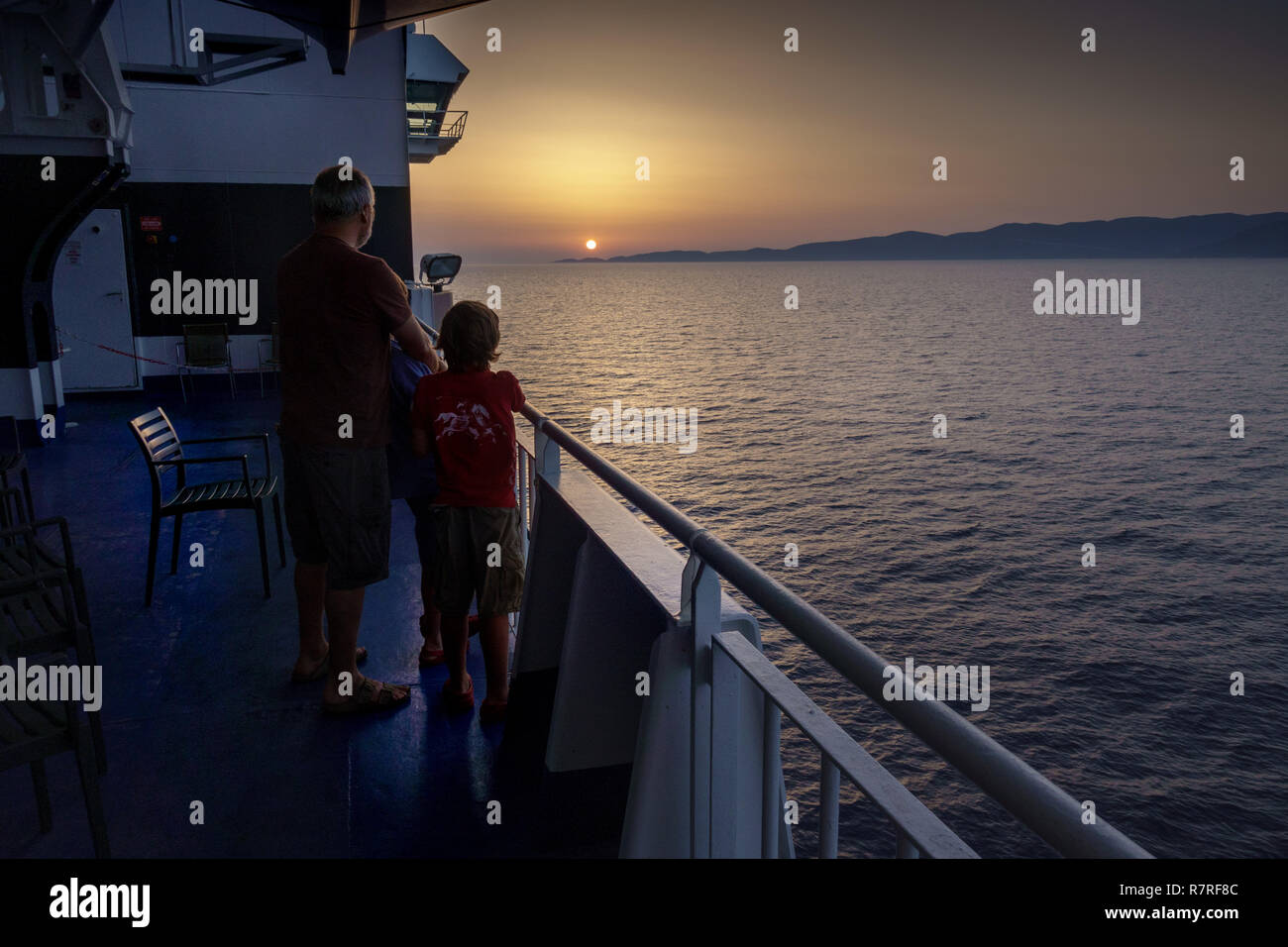 Father and son looking at sunset Stock Photo