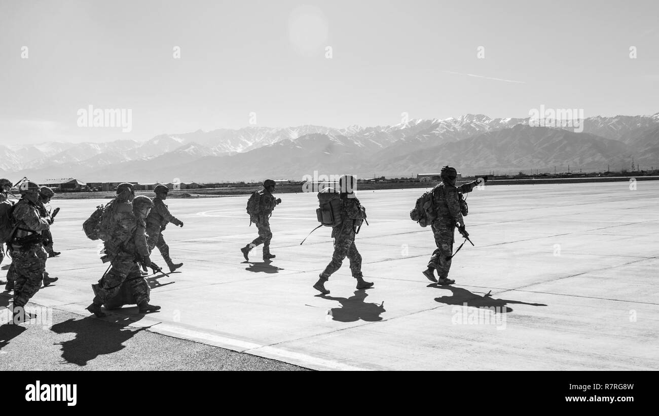 U.S. Army Soldiers assigned to 1st Squadron, 14th Cavalry Regiment, 1st Stryker Brigade Combat Team, 2nd Infantry Division move toward a CH-47 Chinook helicopter assigned to Task Force Flying Dragon, 16th Combat Aviation Brigade, 7th Infantry Division during training at Bagram Airfield, Afghanistan, April 1, 2017. The Cavalry troopers provide a ready response force for downed aircraft, and the training focused on preparing them to assume their mission in support of Operation Freedom’s Sentinel and Resolute Support Mission. Stock Photo