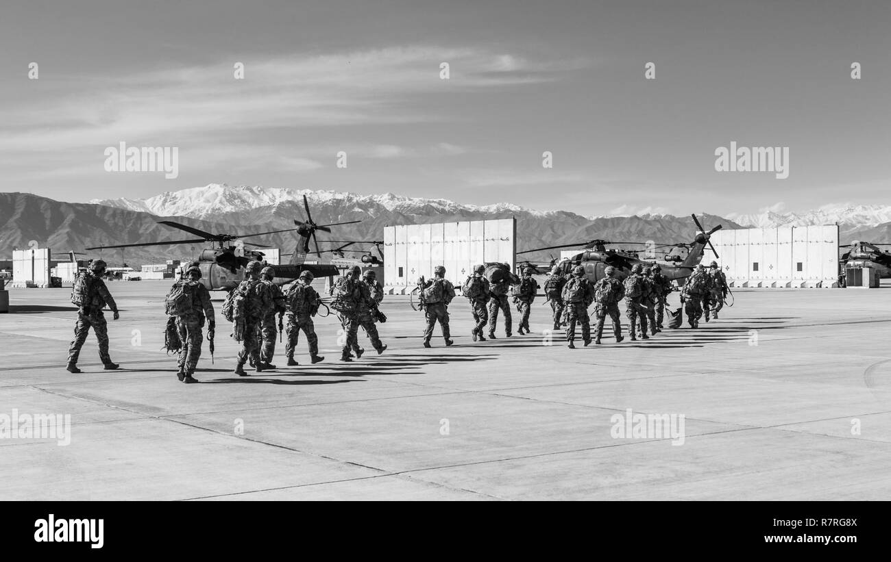 U.S. Army Soldiers assigned to 1st Squadron, 14th Cavalry Regiment, 1st Stryker Brigade Combat Team, 2nd Infantry Division move toward a CH-47 Chinook helicopter assigned to Task Force Flying Dragon, 16th Combat Aviation Brigade, 7th Infantry Division during training at Bagram Airfield, Afghanistan, April 1, 2017. The Cavalry troopers provide a ready response force for downed aircraft, and the training focused on preparing them to assume their mission in support of Operation Freedom’s Sentinel and Resolute Support Mission. Stock Photo