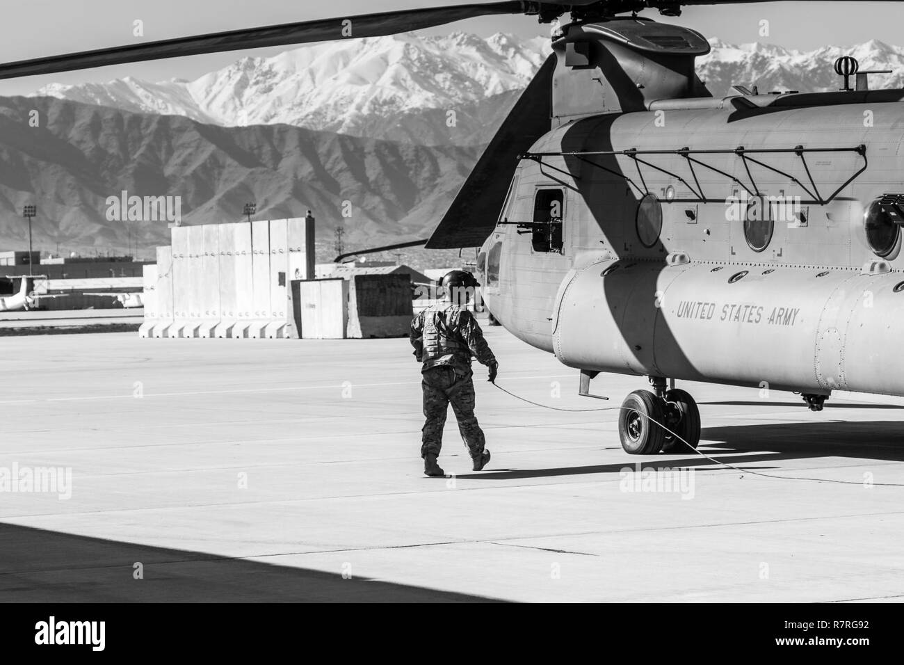 A U.S. Army CH-47 helicopter crew chief assigned to Task Force Flying Dragon, 16th Combat Aviation Brigade, 7th Infantry Division prepares for a flight carrying U.S. Army Soldiers assigned to 1st Squadron, 14th Cavalry Regiment, 1st Stryker Brigade Combat Team, 2nd Infantry Division during training at Bagram Airfield, Afghanistan, April 1, 2017. The Cavalry troopers provide a ready response force for downed aircraft, and the training focused on preparing them to assume their mission in support of Operation Freedom’s Sentinel and Resolute Support Mission. Stock Photo