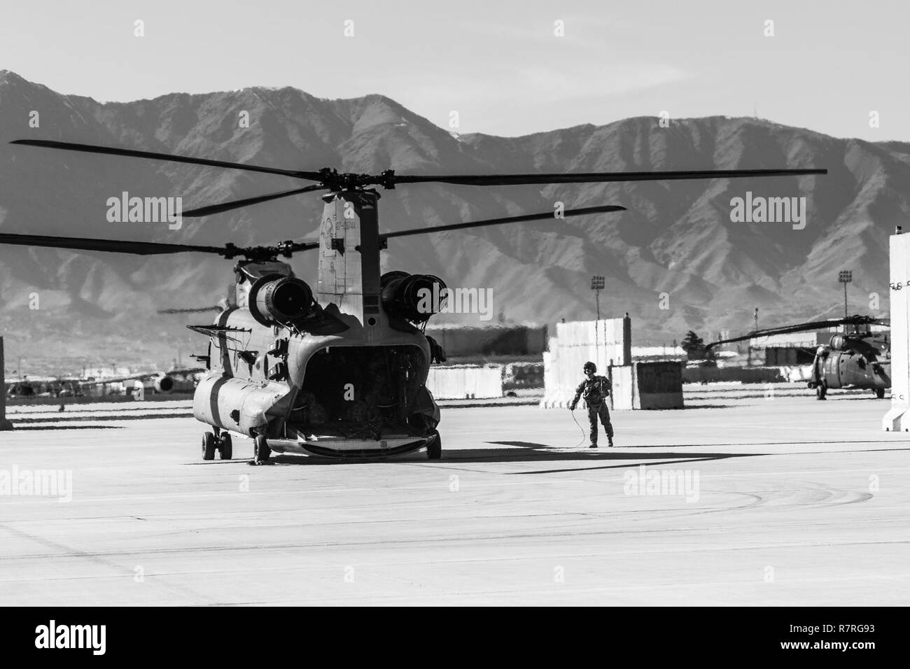 A U.S. Army CH-47 helicopter crew chief assigned to Task Force Flying Dragon, 16th Combat Aviation Brigade, 7th Infantry Division prepares for a flight carrying U.S. Army Soldiers assigned to 1st Squadron, 14th Cavalry Regiment, 1st Stryker Brigade Combat Team, 2nd Infantry Division during training at Bagram Airfield, Afghanistan, April 1, 2017. The Cavalry troopers provide a ready response force for downed aircraft, and the training focused on preparing them to assume their mission in support of Operation Freedom’s Sentinel and Resolute Support Mission. Stock Photo