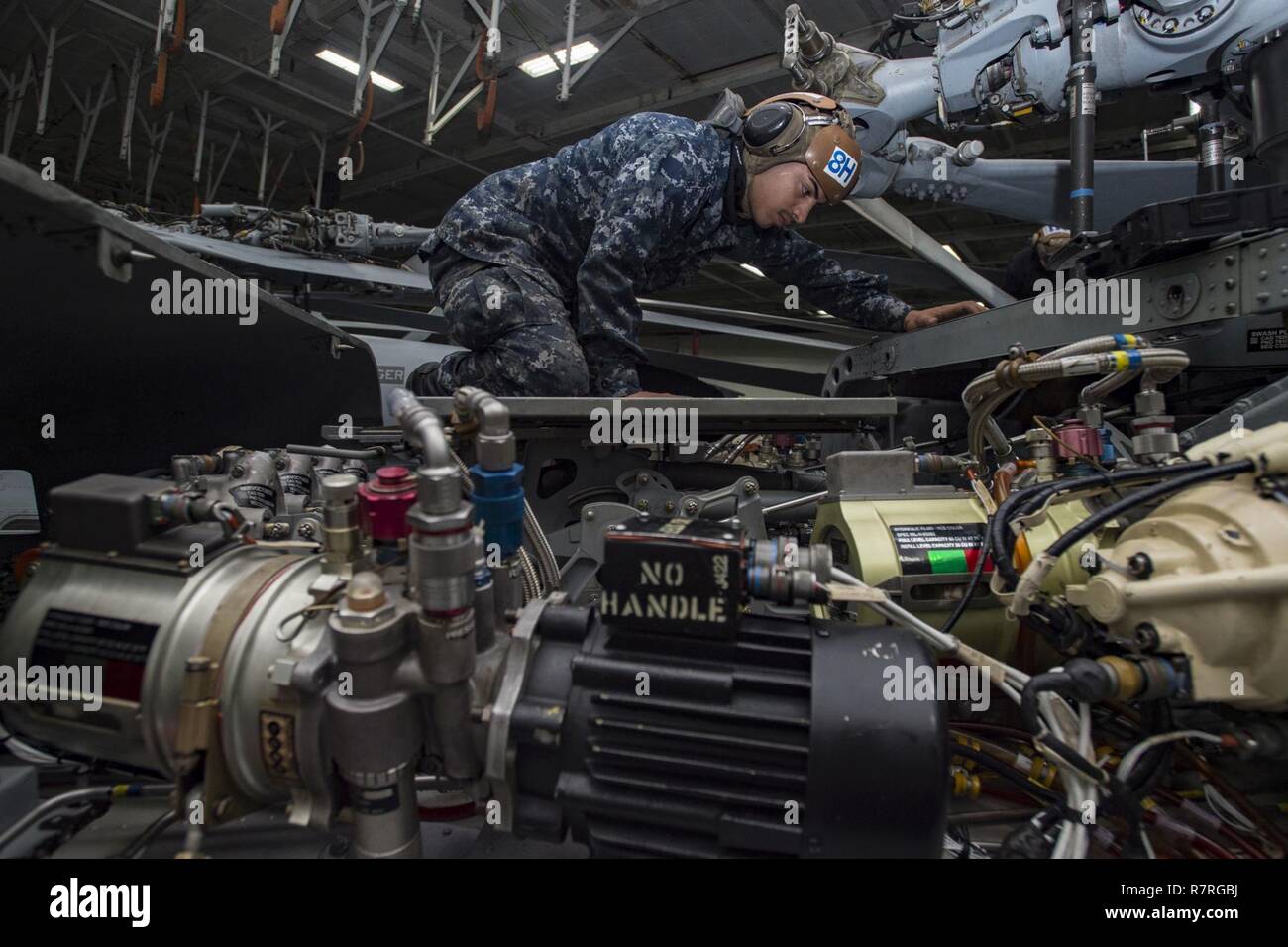 ATLANTIC OCEAN (March 30, 2017) Aviation Structural Mechanic Airman Victor Torres inspects the main rotor pilot of an MH-60R Sea Hawk helicopter assigned to the Swamp Foxes of Helicopter Maritime Strike Squadron (HSM) 74 in the hangar bay of the aircraft carrier USS Dwight D. Eisenhower (CVN 69) (Ike). Ike and its carrier strike group are underway conducting a sustainment exercise in support of the Optimized Fleet Response Plan (OFRP). Stock Photo