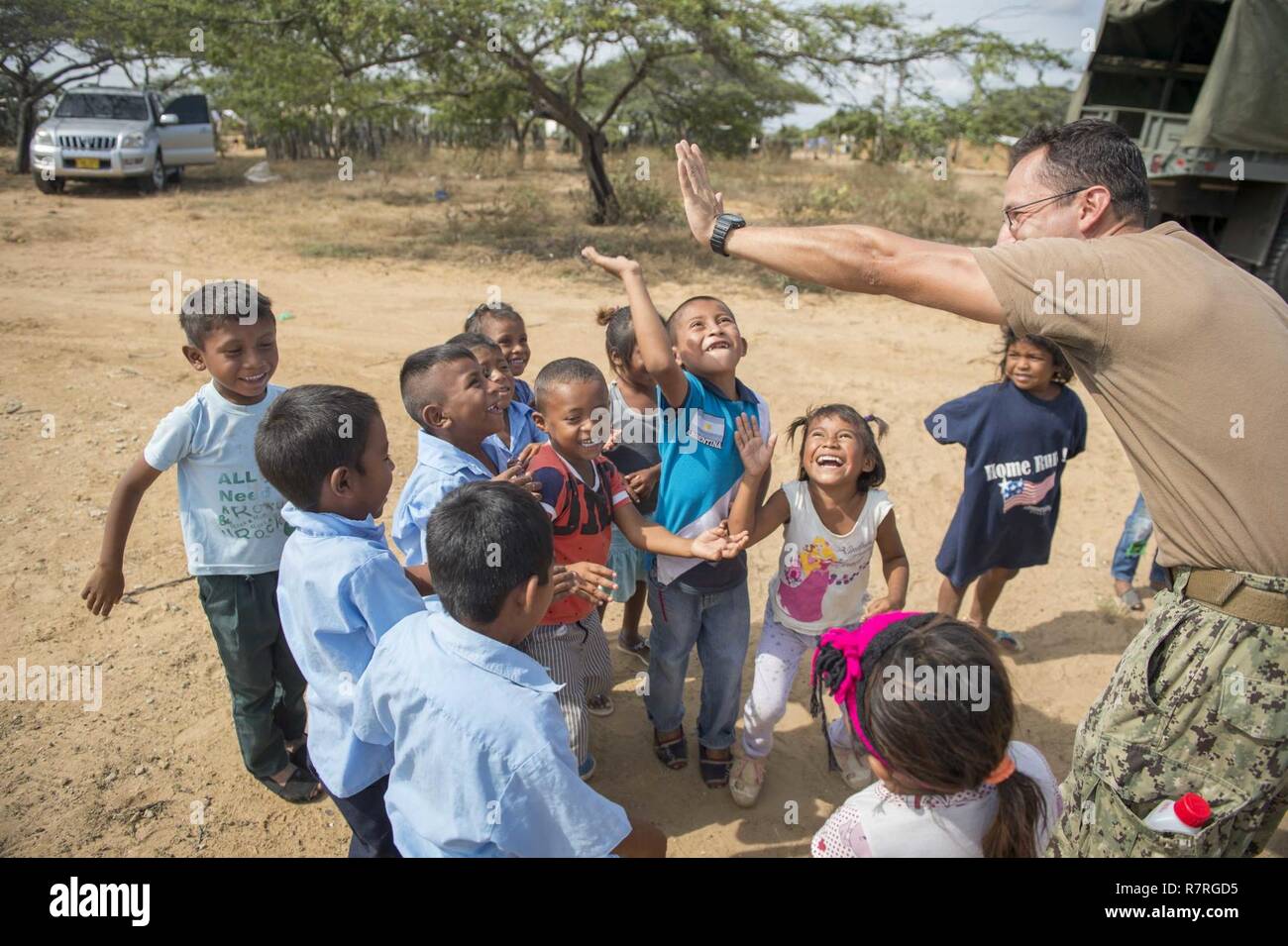 MAYAPO, Colombia (March 30, 2017) - Engineering Aide 2nd Class Gabriel Jimenez, a native of Colombia assigned to Construction Battalion Maintenance Unit (CBMU) 202, high fives children from a Wayuu tribe in Mayapo, Colombia, during Continuing Promise 2017 (CP-17). CP-17 is a U.S. Southern Command-sponsored and U.S. Naval Forces Southern Command/U.S. 4th Fleet-conducted deployment to conduct civil-military operations including humanitarian assistance, training engagements, medical, dental, and veterinary support in an effort to show U.S. support and commitment to Central and South America. Stock Photo