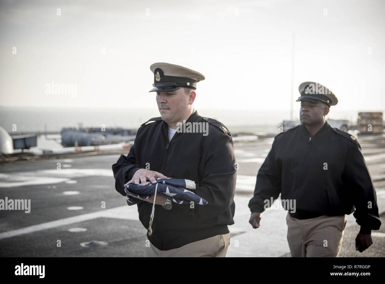NORFOLK, Va. (March 29, 2017) Chief Sonar Technician (Surface) Matthew J. Massetti, left, and Chief Aviation Boatswain's Mate (Handling) Charles Branch prepare to perfom morning colors on the flight deck of aircraft carrier USS Dwight D. Eisenhower (CVN 69) (Ike). Ike is currently pier side during the sustainment phase of the Optimized Fleet Response Plan (OFRP). Stock Photo