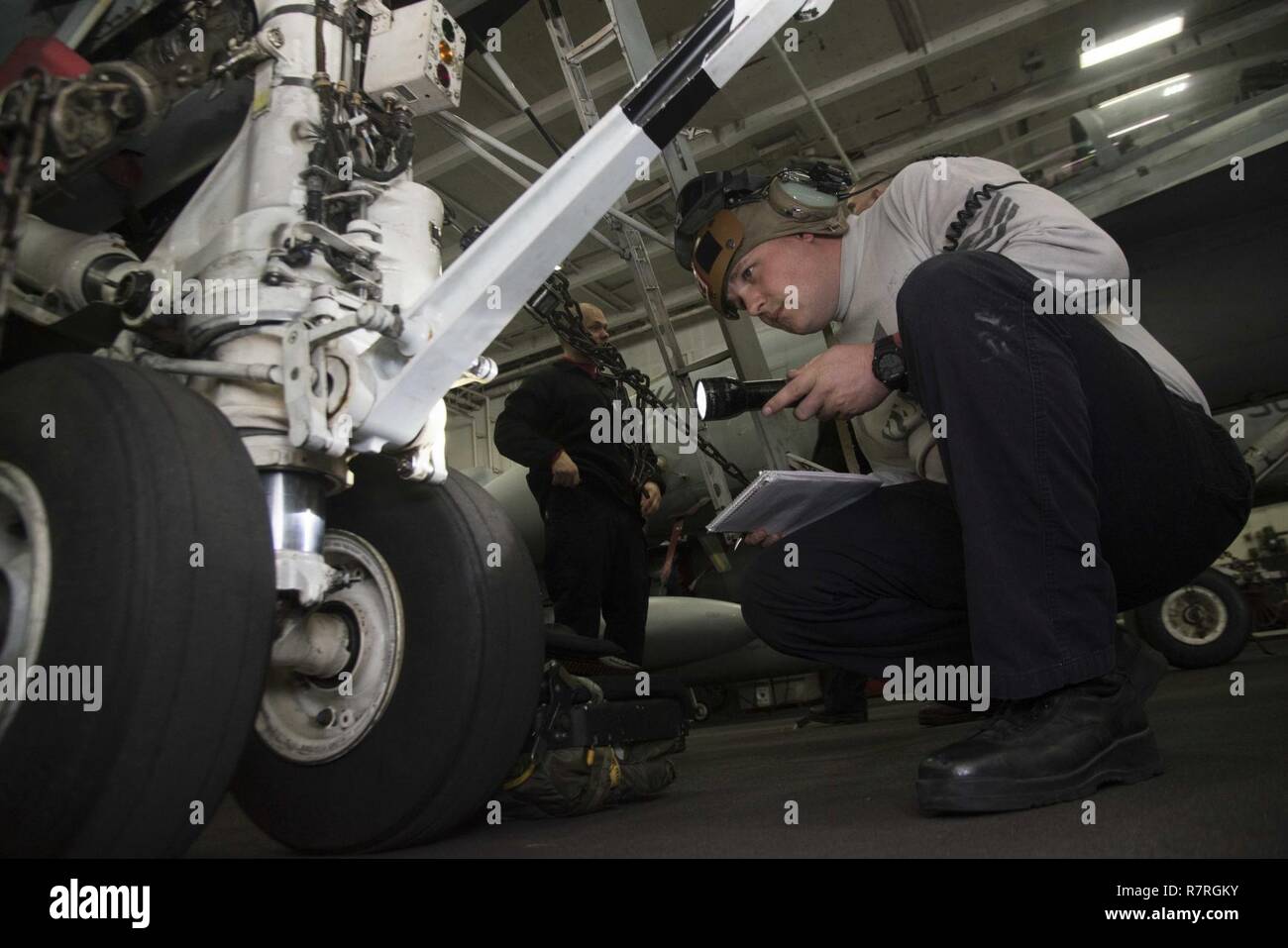 ATLANTIC OCEAN (March 31, 2017) Aviation Structural Mechanic (Equipment) 1st Class Adam Elliott, from Wapakoneta, Ohio, inspects the landing gear of an F/A-18C Hornet assigned to the Wildcats of Strike Fighter Squadron (VFA) 131 in the hangar bay of the aircraft carrier USS Dwight D. Eisenhower (CVN 69) (Ike). Ike and its carrier strike group are underway conducting a sustainment exercise in support of the Optimized Fleet Response Plan (OFRP). Stock Photo