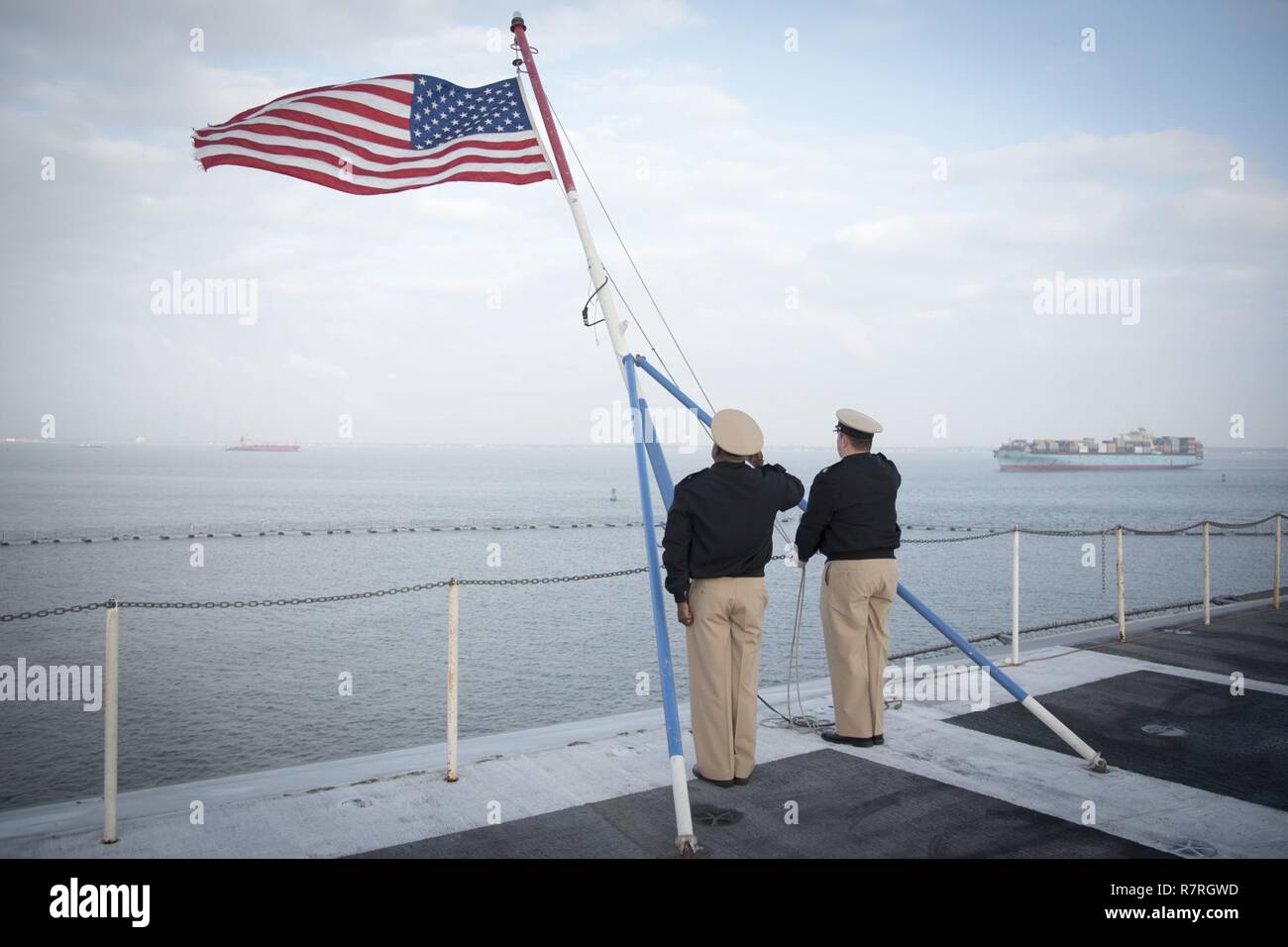 NORFOLK, Va. (March 29, 2017) Chief Aviation Boatswain's Mate (Handling) Charles Branch and Chief Sonar Technician (Surface) Matthew J. Massetti salute the ensign during morning colors on the flight deck of aircraft carrier USS Dwight D. Eisenhower (CVN 69) (Ike). Ike is currently pier side during the sustainment phase of the Optimized Fleet Response Plan (OFRP). Stock Photo