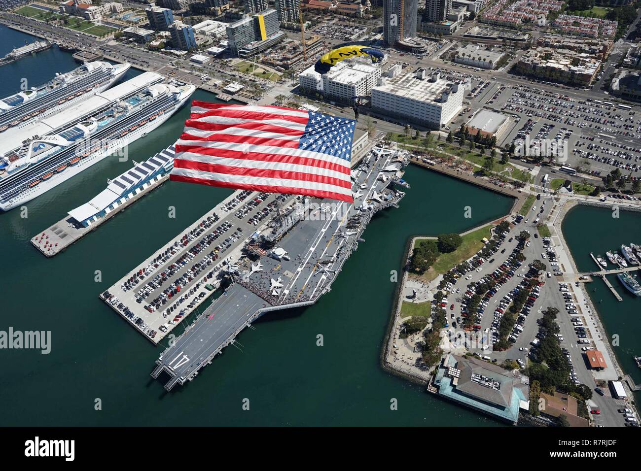SAN DIEGO (March 29, 2017) Special Operator 1st Class T.J. Amdahl, assigned to the U.S. Navy parachute demonstration team, the Leap Frogs, flies the Star-Spangled Banner during a training demonstration above the USS Midway Museum. The Leap Frogs are based in San Diego and perform aerial parachute demonstrations around the nation in support of Naval Special Warfare and Navy recruiting. Stock Photo