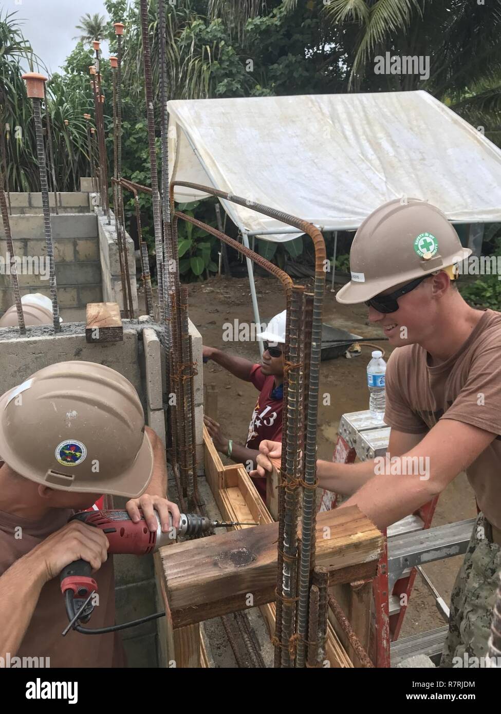 KOSRAE, Micronesia (March 28, 2017) Builder Constructionman Skylar Lunders, right, and Builder 3rd Class Alexander Zebro, both assigned to Naval Mobile Construction Battalion (NMCB) 1, drill framework for the exterior windows on the Walung Health Clinic in Kosrae, Micronesia. NMCB-1 is forward deployed to execute construction, humanitarian and foreign assistance, special operations combat service support, and theater security cooperation in support of U.S. Pacific Command. Stock Photo