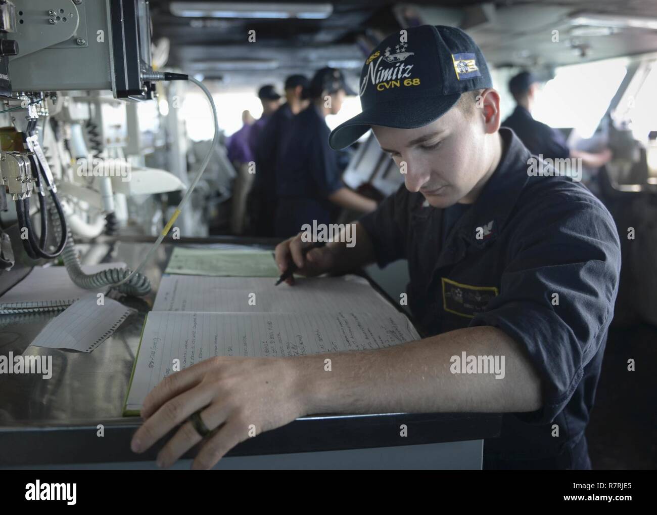 PACIFIC OCEAN (March 31, 2017) Boatswain's Mate 3rd Class Eric Hunt, assigned to the aircraft carrier USS Nimitz (CVN 68), reviews the ship's log before making an entry while underway. Nimitz is underway conducting a composite training unit exercise with it's carrier strike group in preparation for an upcoming deployment. Stock Photo
