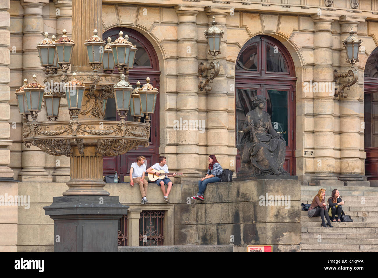 Young people talking, view of young people talking while sitting outside the Rudolfinum concert hall building in Prague, Czech Republic. Stock Photo