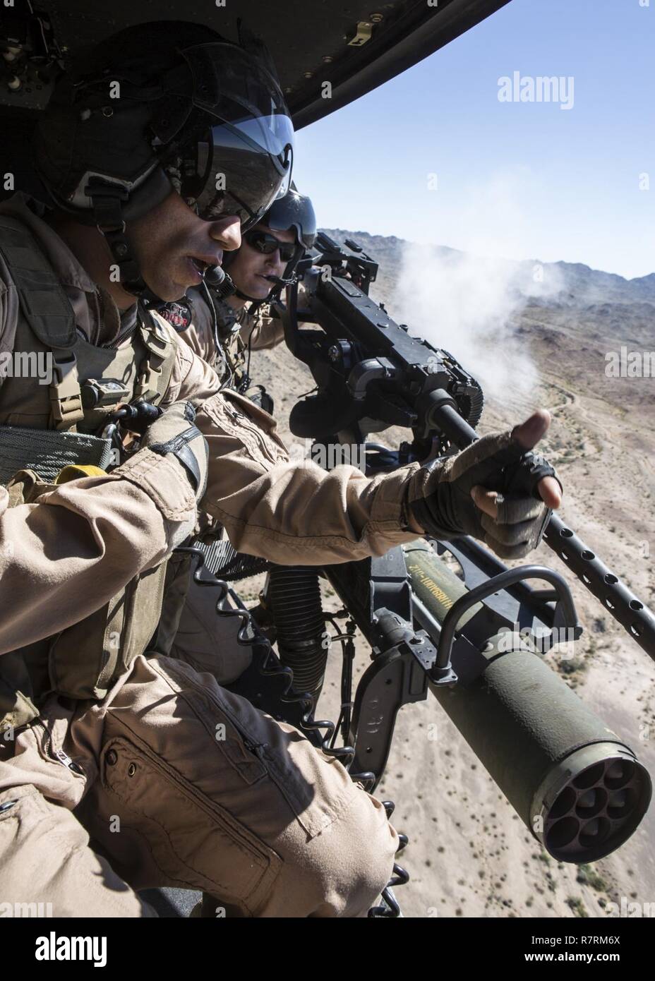 U.S. Marine Corps Staff Sgt. Jared Tape, crew chief with Marine Aviation Weapons and Tactics Squadron One (MAWTS-1), left, instructs U.S. Marine Corps Sgt. Paul Guillen, crew chief with Marine Light Attack Helicopter Squadron-169, right, on how to aim the GAU-21 during an aerial gunnery refinement at Weapons and Tactics Instructor Course (WTI) 2-17, at Chocolate Mountain Aerial Gunnery Range, Calif., April 5, 2017. WTI is a seven-week training event hosted by MAWTS-1 cadre, which emphasizes operational integration of the six functions of Marine Corps aviation in support of a Marine Air Ground  Stock Photo