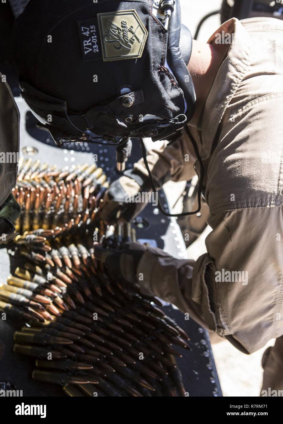 U.S. Marine Corps Sgt. Paul Guillen, crew chief with Marine Light Attack Helicopter Squadron-169, restocks his ammo during an aerial gunnery refinement at Weapons and Tactics Instructor Course (WTI) 2-17, at Chocolate Mountain Aerial Gunnery Range, Calif., April 5, 2017. WTI is a seven-week training event hosted by Marine Aviation Weapons and Tactics Squadron One (MAWTS-1) cadre, which emphasizes operational integration of the six functions of Marine Corps aviation in support of a Marine Air Ground Task Force and provides standardized advanced tactical training and certification of unit instru Stock Photo
