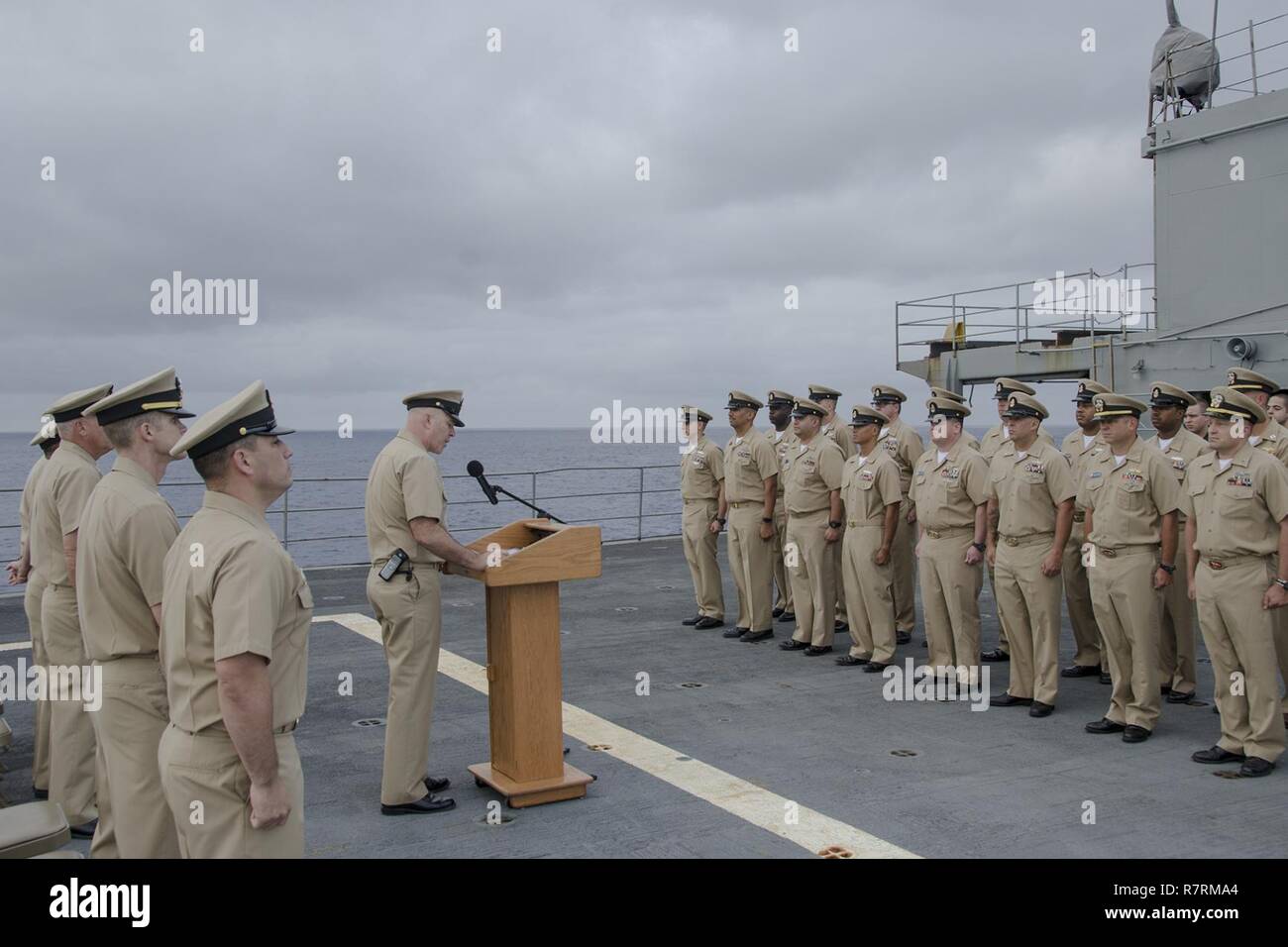 PACIFIC OCEAN (April 1, 2017) Command Master Chief Wade Tandberg reads the Chief Petty Officer’s Creed aboard the submarine tender USS Frank Cable (AS 40), during the Chief’s 124th birthday celebration on the flight deck, April 1.  Frank Cable, en route to Portland, Ore. for her dry-dock phase maintenance availability, conducts maintenance and supports submarines and surface vessels deployed to the Indo-Asia-Pacific region. Stock Photo