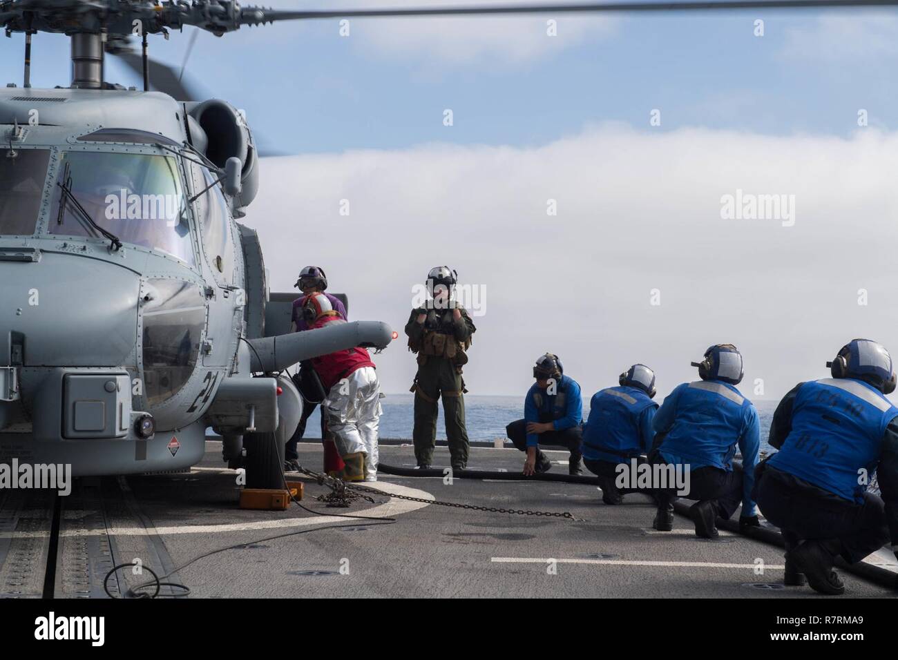 PACIFIC OCEAN (April 2, 2017) Sailors aboard the Ticonderoga-class guided-missile cruiser USS Lake Erie (CG 70) refuel an MH-60R Sea Hawk helicopter assigned to the 'Scorpions' of Helicopter Maritime Strike Squadron (HSM) 49 while underway conducting a composite training unit exercise (COMPTUEX) with the Nimitz Carrier Strike Group in preparation for an upcoming deployment. COMPTUEX tests the mission-readiness of the strike group's assets through simulated real-world scenarios and their ability to perform as an integrated unit. Stock Photo