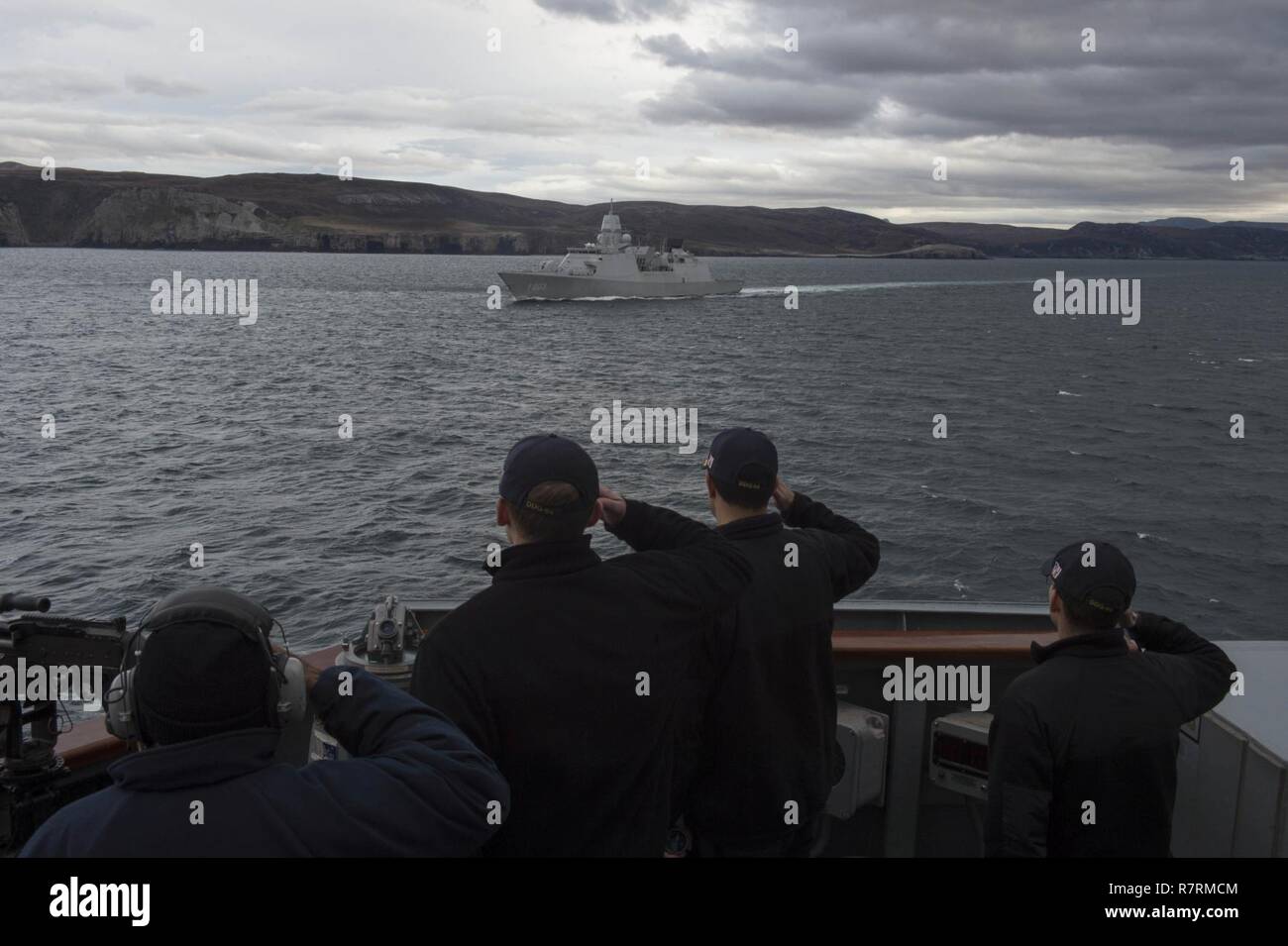 CAPE WRATH, Scotland (April 3, 2017) Sailors assigned to the Arleigh Burke-class guided-missile destroyer USS Carney (DDG 64) render honors to Royal Netherlands Navy frigate HNLMS Tromp (F803) during exercise Joint Warrior 17-1. Carney is forward-deployed to Rota, Spain, conducting its third patrol in the U.S. 6th Fleet area of operations in support of U.S. national security interests in Europe. Stock Photo