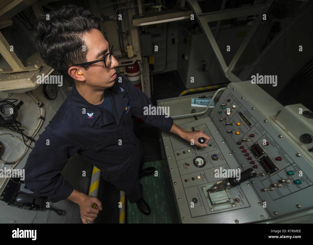 WATERS SURROUNDING THE KOREAN PENNINSULA (March 31, 2017) Sonar Technician (Surface) 3rd Class Juan Browndoig, from Pensacola, Florida, operates a multifunctional towed array (MFDA) console from Arleigh Burke-class guided-missile destroyer USS Barry (DDG 52) during a simulated submarine hunting exercise. Barry is participating in a Surface Ship Anti-Submarine Warfare Readiness and Effectiveness Measure (SHAREM) exercise, which is a multi-national exercise designed to strengthen interoperability of the U.S. and Republic of Korea Navies. Stock Photo