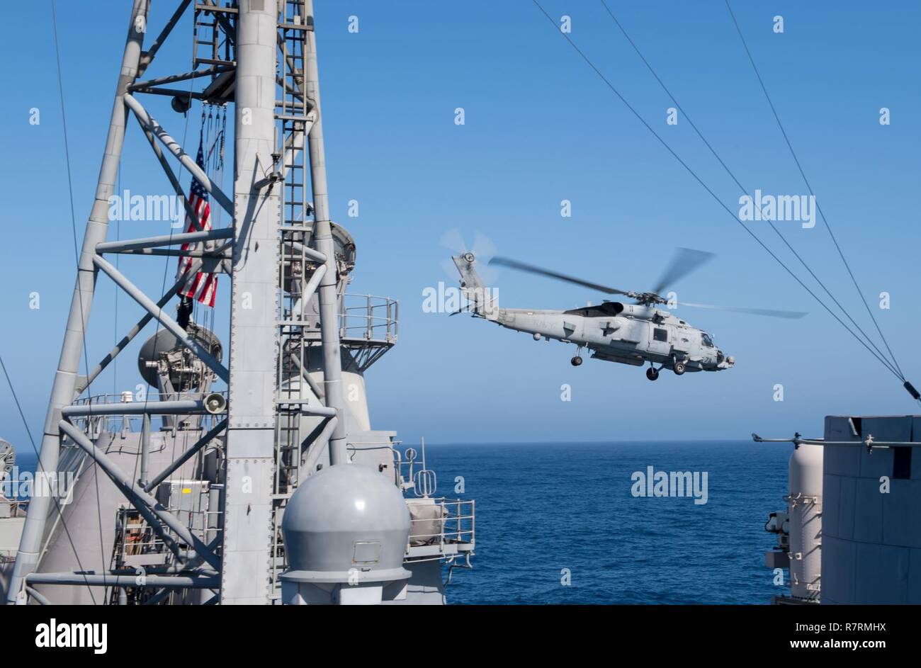 PACIFIC OCEAN (April 1, 2017) An MH-60R Sea Hawk helicopter assigned to the 'Wolfpack' of Helicopter Maritime Strike Squadron (HSM) 75 departs the Ticonderoga-class guided-missile cruiser USS Princeton (CG 59) during a composite training unit exercise (COMPTUEX) with the Nimitz Carrier Strike Group in preparation for an upcoming deployment. COMPTUEX tests the mission readiness of the strike group's assets through simulated real-world scenarios and their ability to perform as an integrated unit. Stock Photo