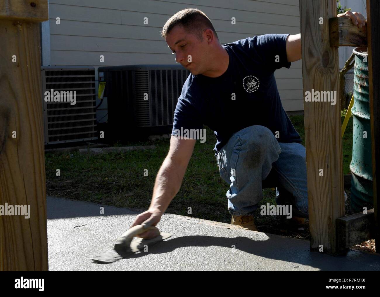 GULFPORT, Miss. (April 4, 2017) Chief Builder Andrew Brandmeier, with Navy Construction Group 2 Chief Petty Officer Association, finishes a handicap ramp poured during a community outreach event held at the South Mississippi Mental Health Association in Gulf Port Miss. Gulfport/Biloxi is one of select regions to host a 2017 Navy Week, a week dedicated to raise U.S. Navy awareness in through local outreach, community service and exhibitions. Stock Photo