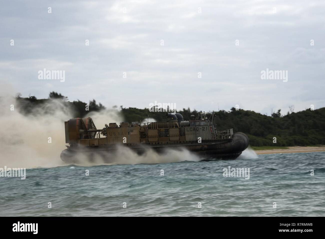 KIN BLUE BEACH, Okinawa (April 5, 2017) Landing craft air cushion (LCAC) 21, assigned to Naval Beach Unit (NBU) 7, returns to the amphibious assault ship USS Bonhomme Richard (LHD 6) during a 31st Marine Expeditionary Unit (MEU) offload. Bonhomme Richard, flagship of the Bonhomme Richard Expeditionary Strike Group, with embarked 31st MEU, is on a patrol, operating in the Indo-Asia-Pacific region to enhance warfighting readiness and posture forward as a ready-response force for any type of contingency. Stock Photo