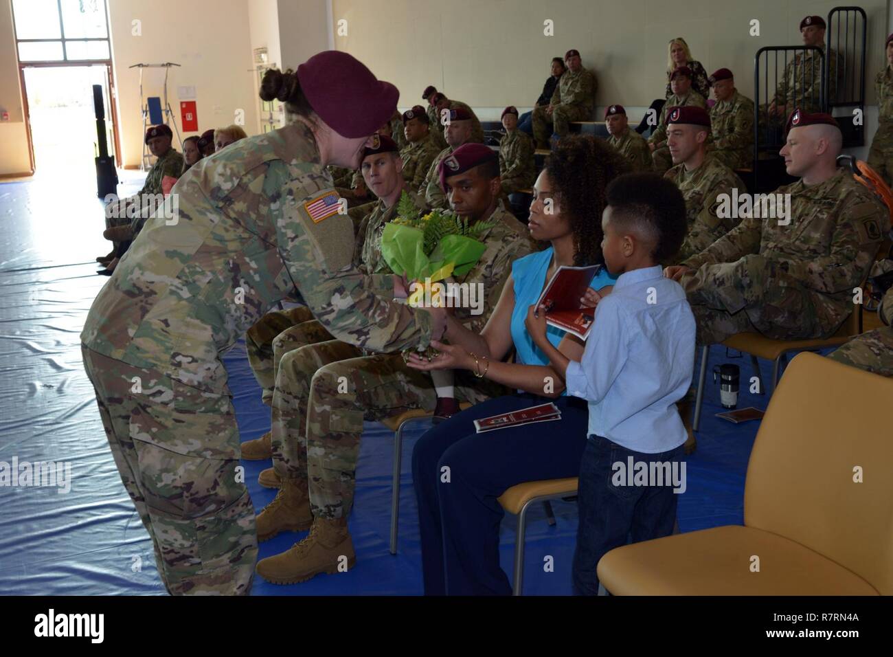 Wife of incoming 1st Sgt. Steven C. Manuel, receives a bouquet of yellow roses from a paratrooper during the change of responsibility ceremony for Company C, 54th Brigade Engineer Battalion, 173rd Airborne Brigade, Apr. 5, 2017 at Caserma Del Din in Vicenza, Italy. The 173rd Airborne Brigade based in Vicenza, Italy, is the Army Contingency Response Force in Europe, and is capable of projecting forces to conduct the full of range of military operations across the United State European, Central and Africa Commands areas of responsibility. Stock Photo