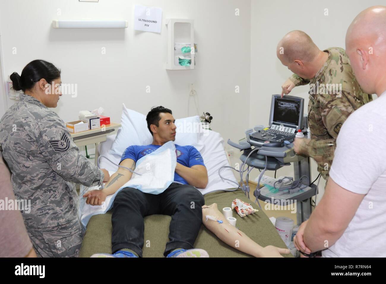 U.S. Air Force Tech Sgt. Catalina L. Meissner (left), medical service technician with the 386th Medical Group, uses an Ultrasound Guided Peripheral i.v. to locate the best placement of the needle in the vein, April 1, at Camp Arifjan, Kuwait. The medical refresher training, conducted by the 31st Combat Support Hospital, was for U.S. Army Central area of operation’s nurses and medics, who do not always get chances to work with trauma assessments Stock Photo