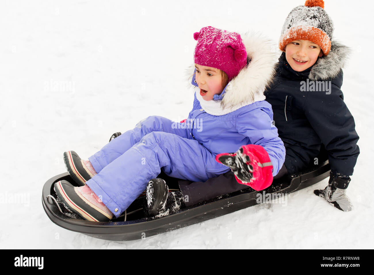 little kids sliding on sled down hill in winter Stock Photo Alamy
