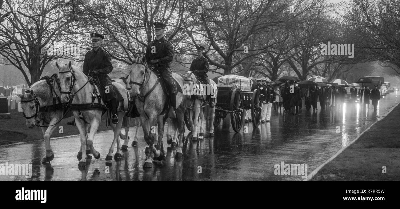 U.S. Army Soldiers with caisson platoon, 1st Battalion, 3rd United States Infantry Regiment, ride their horses through Arlington National Cemetery during a funeral for retired Marine Col. John H. Glenn Jr., Arlington, Va., April 6, 2017. Glenn passed away Dec. 8, 2016. Glenn was a U.S. Marine aviator who flew 149 combat missions during World War II and the Korean War. He later became a NASA astronaut and was the first man to orbit the earth aboard the “Friendship 7” in 1962. He was then elected to the U.S. Senate for the state of Ohio in 1974 and served four consecutive terms. Stock Photo