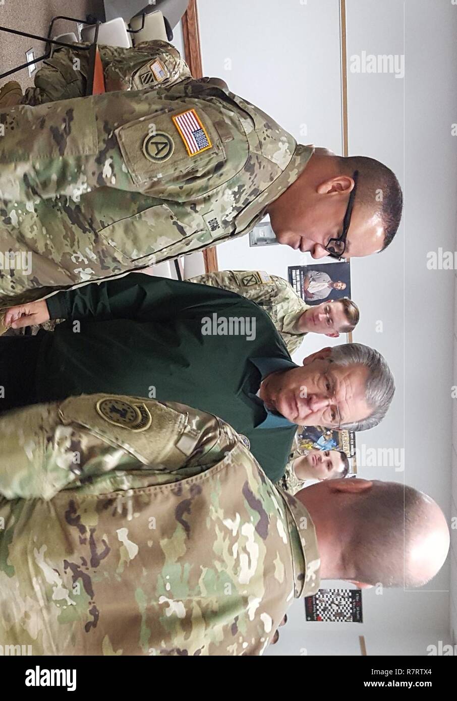 Brig. Gen. Jose R. Burgos (left) deputy commanding general of the 99th Regional Support Command, Joint Base McGuire-Dix-Lakehurst, N.J., speaks with Mr. Melvin Bauman (middle), Army Reserve Ambassador for the state of Michigan and Army Master Sgt. Jeffrey W. Cole (right), the noncommissioned officer in charge of operations for the U.S. Army Great Lakes Recruiting Battalion, Lansing, Mich., March 25, 2017, in the George B. Dolliver U.S. Army Reserve Center in Fort Custer Training Center, Mich. Bauman is a retired Army Reserve Lt. Col. with over 35 years of service. Stock Photo