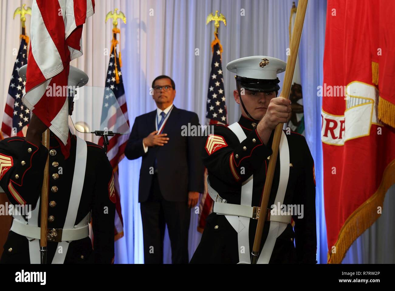 Marine Corps Sgt. Michael Thomas, right, recruiter of substation Costa  Mesa, lowers the Marine Corps flag during the Ellis Island Medal of Honor  Ceremony at the Westin South Coast Plaza, Costa Mesa,