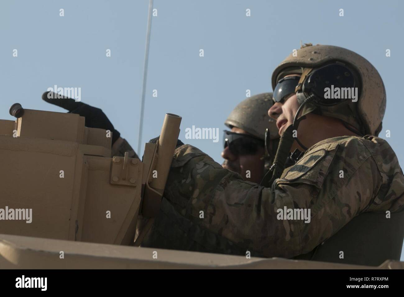 An M2A3 Bradley Fighting Vehicle crew from the 3rd Armored Brigade Combat Team, 1st Cavalry Division discusses targeting in preparation for their turn to execute Table VI qualification at the Udairi Range Complex March 27. The brigade tank and Bradley crews spent about two weeks in the field conducting sustainment gunnery to ensure all the crews qualified at day and night fire to maintain proficiency. Stock Photo