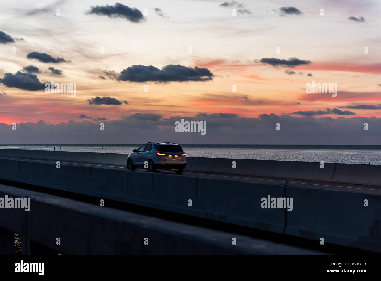 Sunrise in Islamorada, Florida Keys, with red orange yellow sky, car on overseas highway road, in Atlantic Ocean, gulf of Mexico, horizon Stock Photo