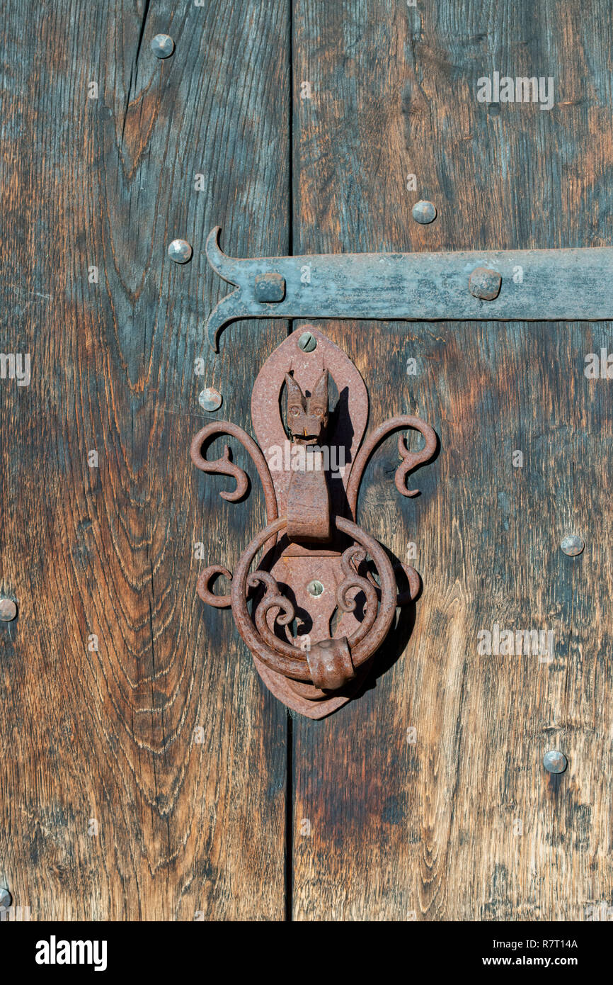 Rustic Dragons head door knocker on an old wooden door in Chipping campden, Cotswolds, Gloucestershire, UK Stock Photo