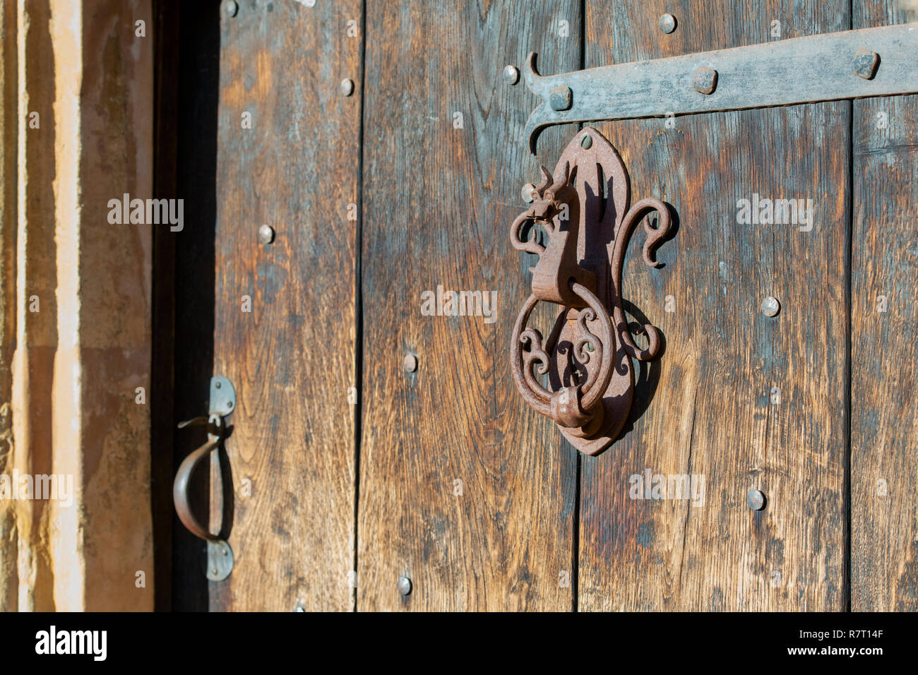 Rustic Dragons head door knocker on an old wooden door in Chipping campden, Cotswolds, Gloucestershire, UK Stock Photo