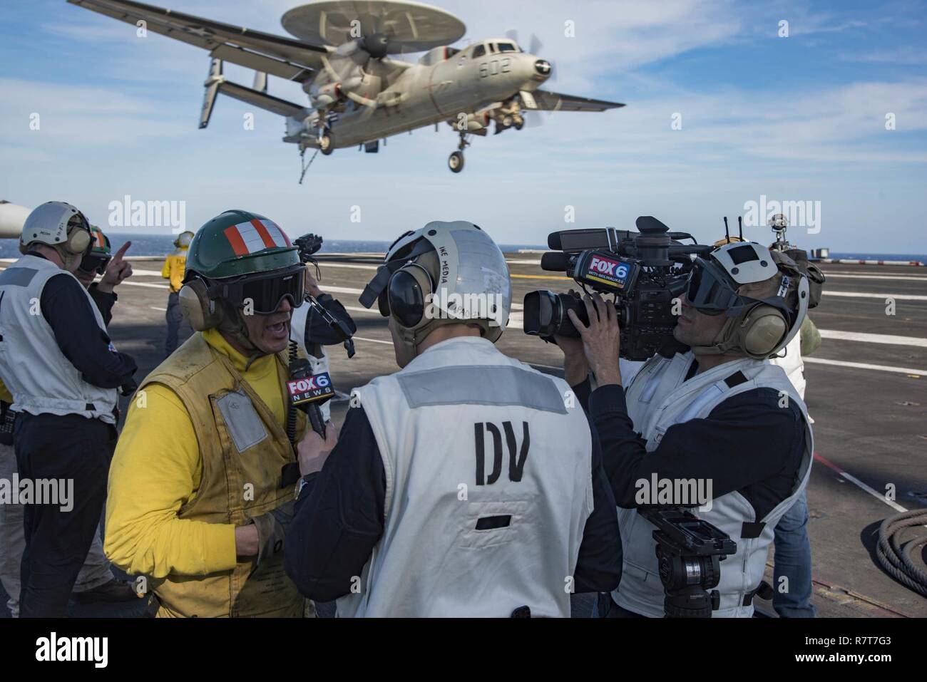 ATLANTIC OCEAN (April 4, 2017) Lt. William Lee Tschumy, from Panama City, speaks with Milwaukee reporter Carl Deffenbaughon on the flight deck of the aircraft carrier USS Dwight D. Eisenhower (CVN 69). The ship and its carrier strike group are underway conducting a sustainment exercise in support of the Optimized Fleet Response Plan (OFRP). Stock Photo