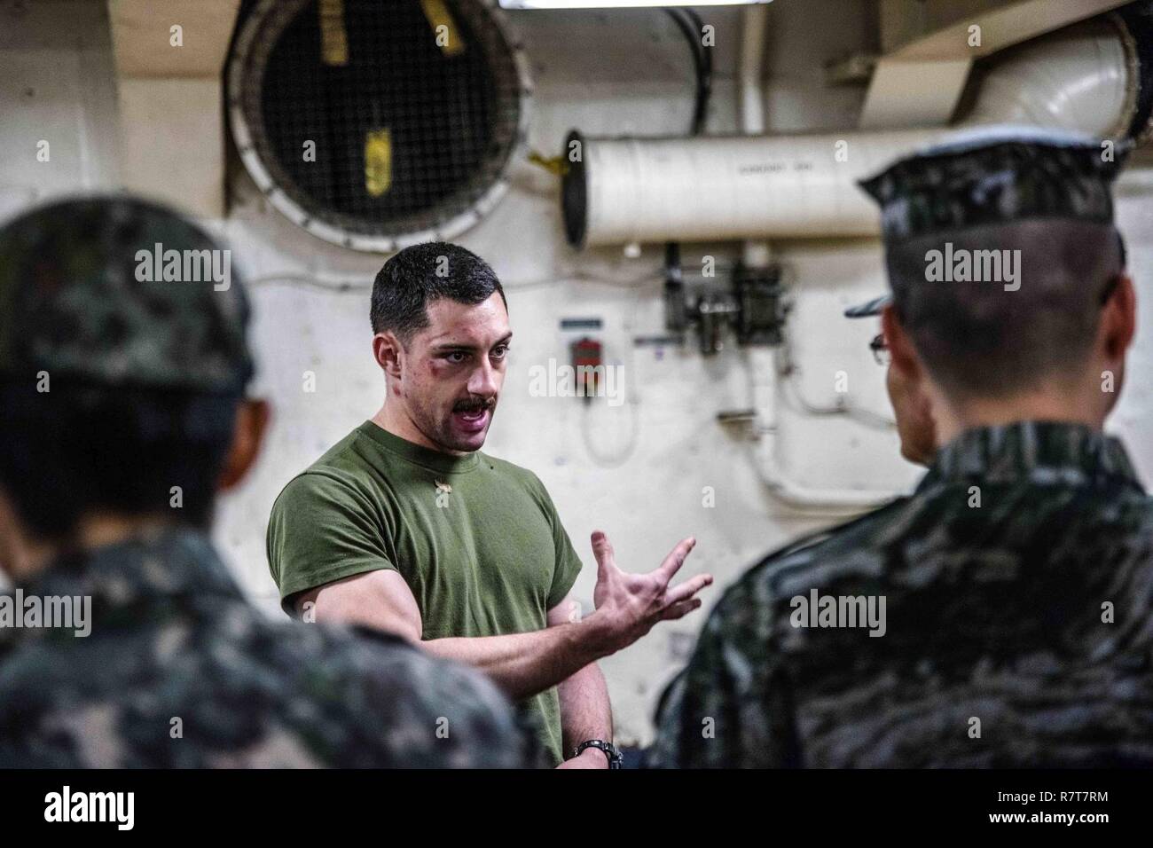 WATERS EAST OF THE KOREAN PENINSULA (April 1, 2017) U.S. Marine Corps Sgt. Justin Hutcher, from Hendersonville, N.C., explains the Marine Corps Martial Arts Program to Republic of Korea Navy and Army personnel aboard the amphibious transport dock USS Green Bay (LPD 20) during the U.S. Pacific Command Amphibious Leaders Symposium (PALS). Green Bay, part of the Bonhomme Richard Expeditionary Strike Group, with embarked 31st Marine Expeditionary Unit, is on a routine patrol, operating in the Indo-Asia-Pacific region to enhance warfighting readiness and posture forward as a ready-response force fo Stock Photo