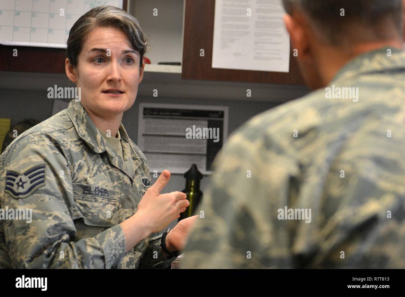 U.S. Air Force Staff Sgt. Molly Elder, 20th Fighter Wing (FW) Public Affairs (PA) broadcast journalist craftsman, speaks with an Airman about a project at Shaw Air Force Base, S.C., March 21, 2017. Before any product, written, photographic or video is posted to Shaw’s official communication outlets it must undergo extensive review for accuracy, brevity, operational security and critical information. Stock Photo
