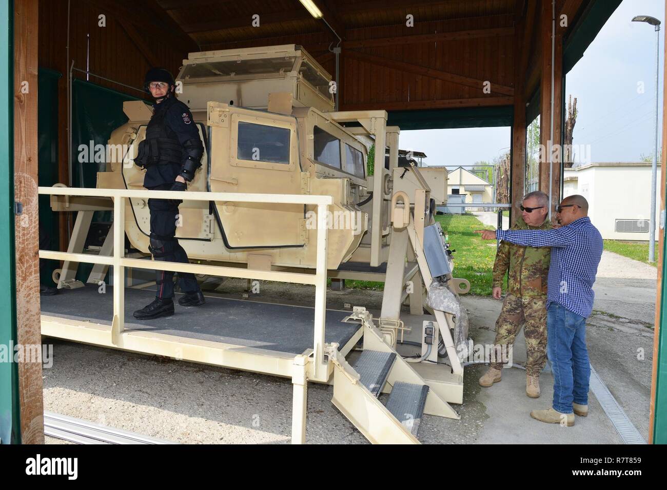Joseph Gallegos, Training Specialist, Training Support Center Italy, shows the High Mobility Multipurpose Wheeled Vehicle (HMMWV) egress assistance trainer (HEAT), to the Sgt. Maj. Massimo Giordano Italian Army, during the training Italian  Carabinieri of the 7th Regiment Carabinieri “Laives” Bolzano and 13th Regiment Carabinieri “Friuli Venezia Giulia” Gorizia, at Caserma Ederle, April 6, 2017, Vicenza, Italy. The simulator allows soldiers to practice exit from vehicles, skills and engage in realistic scenarios. Carabinieri use U.S. Army RTSD South equipment to enhance bilateral relations and Stock Photo