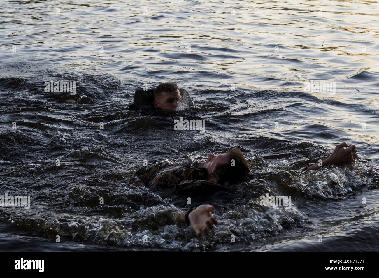 U.S. Army rangers swim across a pond during the Best Ranger Competition 2017 at Fort Benning, Ga., April 7, 2017. The 34th annual David E. Grange Jr. Best Ranger Competition 2017 is a three-day event consisting of challenges to test competitor's physical, mental, and technical capabilities. Stock Photo